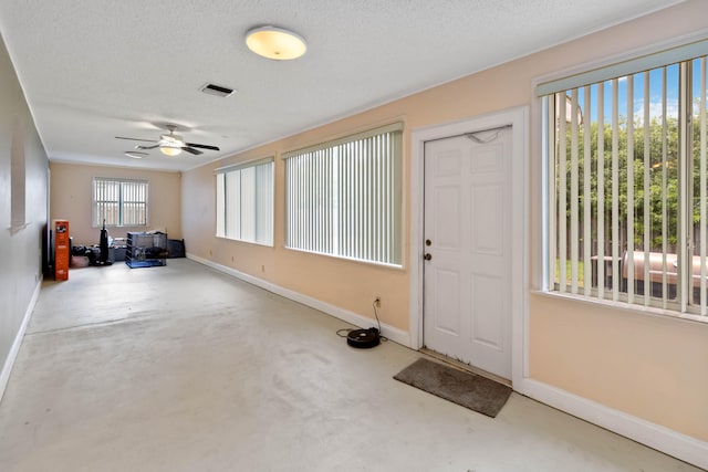 interior space featuring plenty of natural light, ceiling fan, and a textured ceiling