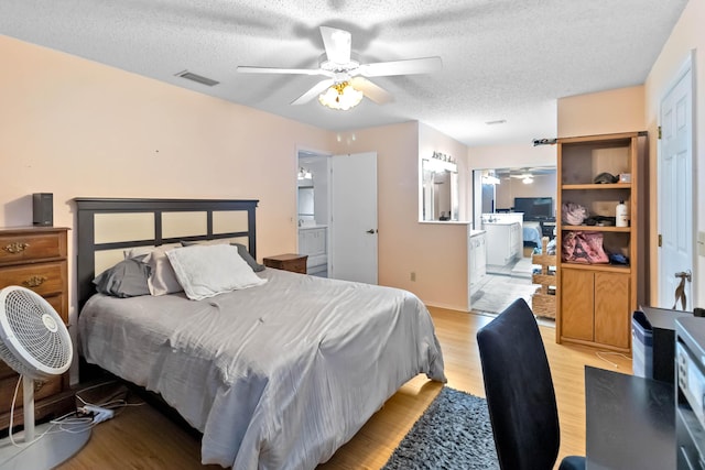 1632 Cains Ave NW, Palm Bay, FL 32907 - bedroom featuring ensuite bathroom, light wood finished floors, a textured ceiling, and visible vents