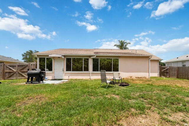 1632 Cains Ave NW, Palm Bay, FL 32907 - rear view of house featuring a fenced backyard, a gate, stucco siding, and a lawn