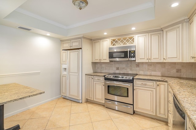 kitchen with tasteful backsplash, light tile patterned flooring, cream cabinetry, and appliances with stainless steel finishes