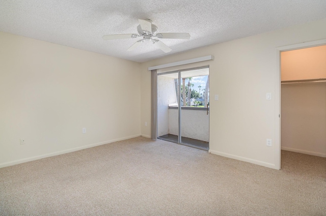 unfurnished bedroom with carpet flooring, a walk in closet, ceiling fan, and a closet