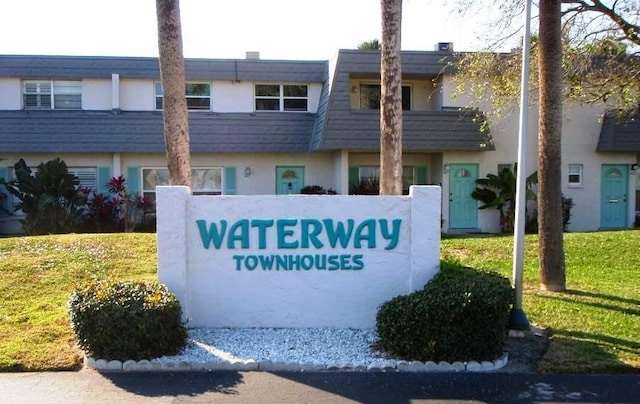 community / neighborhood sign featuring a lawn