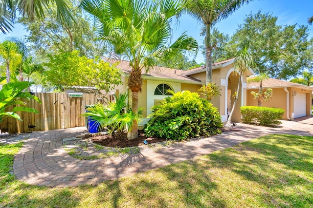 mediterranean / spanish home featuring a garage and a front lawn