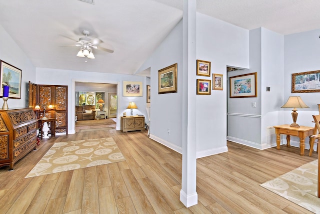 interior space with ceiling fan, light hardwood / wood-style floors, and lofted ceiling