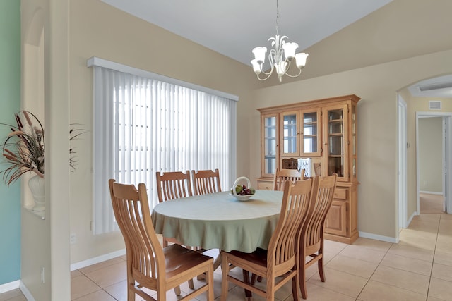 tiled dining area featuring a wealth of natural light, lofted ceiling, and an inviting chandelier