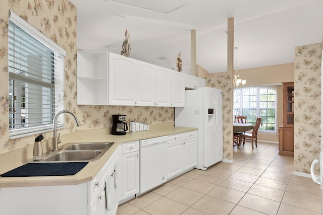 kitchen featuring a notable chandelier, white cabinets, white appliances, and lofted ceiling