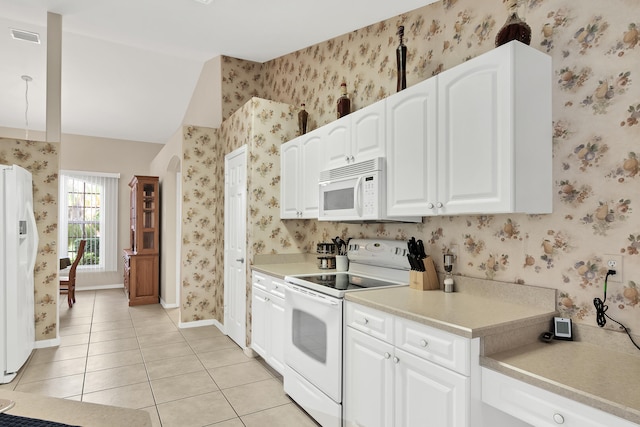 kitchen featuring vaulted ceiling, white cabinets, white appliances, and light tile floors