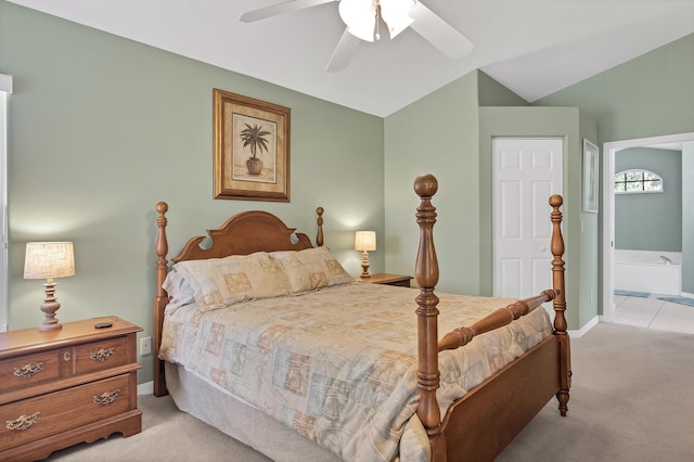 carpeted bedroom with ensuite bathroom, ceiling fan, and vaulted ceiling