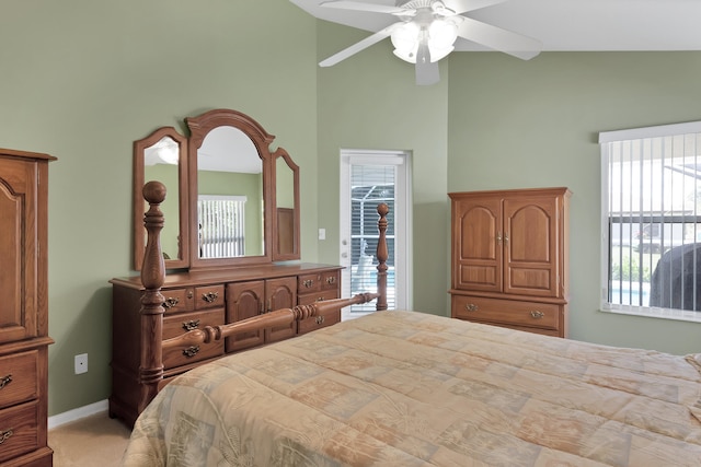 carpeted bedroom with high vaulted ceiling, ceiling fan, and multiple windows