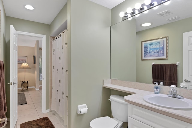 bathroom with tile flooring, vanity, and toilet