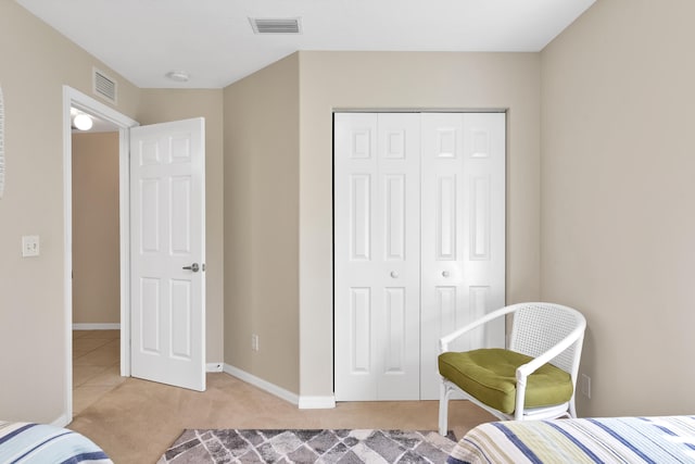 bedroom featuring a closet and light tile floors