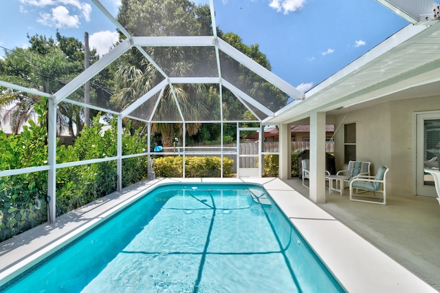 view of pool with a patio and glass enclosure