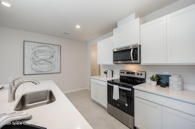 kitchen featuring stainless steel appliances, sink, and white cabinets