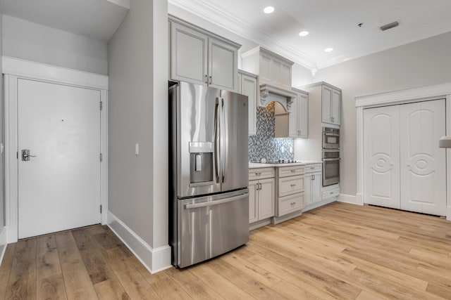 kitchen with stainless steel appliances, backsplash, crown molding, light wood-type flooring, and gray cabinets