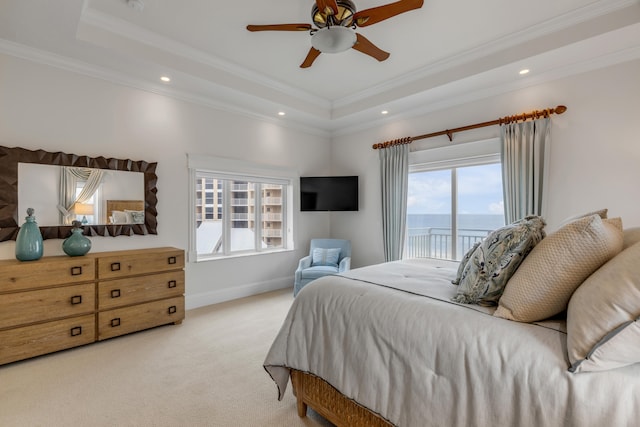 carpeted bedroom with access to outside, a tray ceiling, multiple windows, and ceiling fan