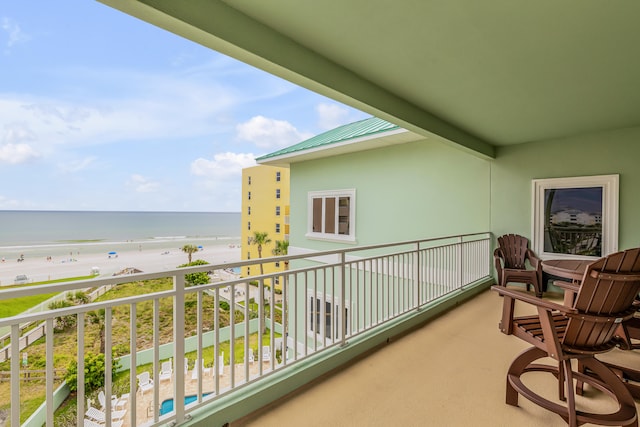 balcony featuring a view of the beach and a water view