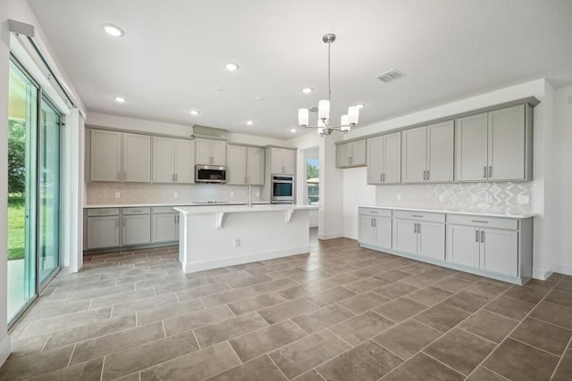 kitchen featuring appliances with stainless steel finishes, light tile patterned floors, tasteful backsplash, and plenty of natural light