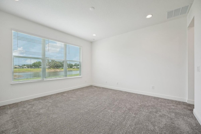 empty room featuring recessed lighting, carpet, visible vents, and baseboards