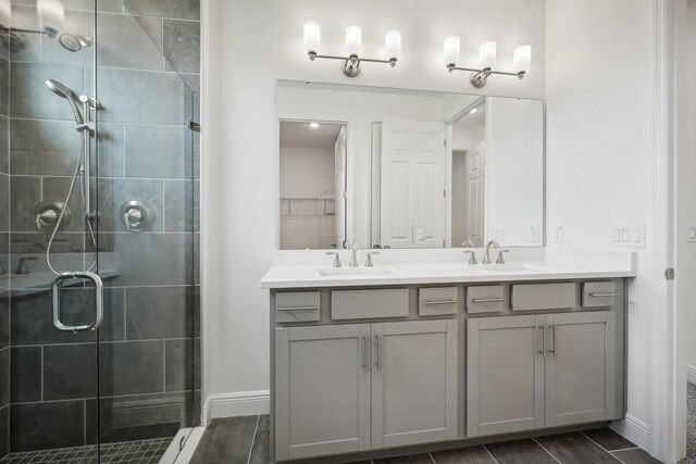 bathroom with double vanity, an enclosed shower, and tile patterned flooring