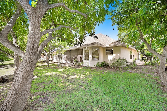 view of front of house featuring a sunroom and a front yard