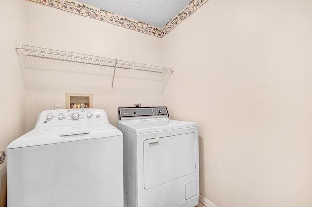 clothes washing area featuring independent washer and dryer and a textured ceiling