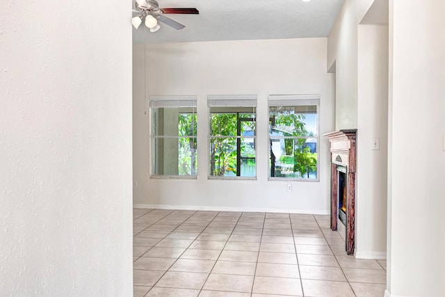 unfurnished living room featuring ceiling fan, light tile patterned floors, and a textured ceiling