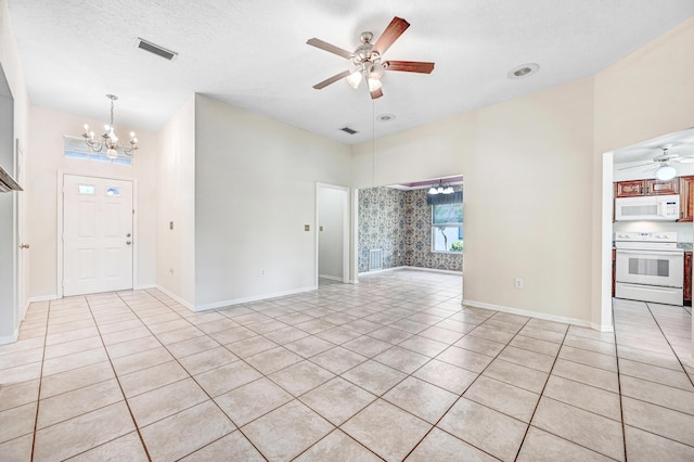 spare room featuring a textured ceiling, light tile patterned floors, and ceiling fan with notable chandelier