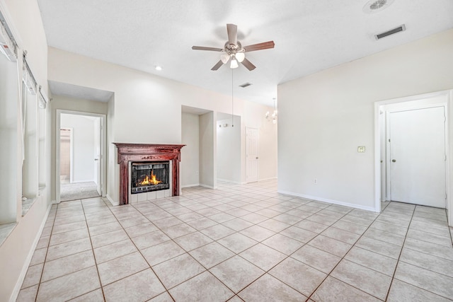 unfurnished living room with ceiling fan with notable chandelier and light tile patterned floors