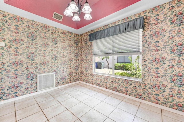 tiled empty room with an inviting chandelier