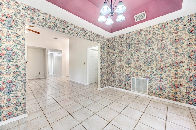 spare room with light tile patterned floors and ceiling fan with notable chandelier