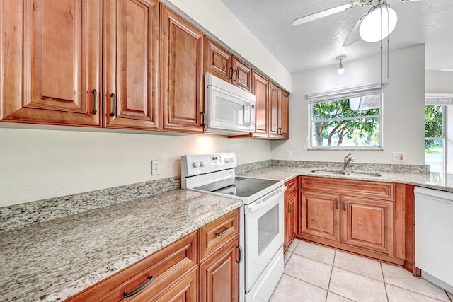 kitchen featuring light stone countertops, sink, ceiling fan, a textured ceiling, and white appliances