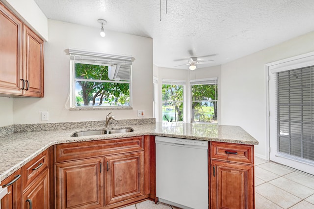 kitchen featuring a wealth of natural light, dishwasher, ceiling fan, and sink