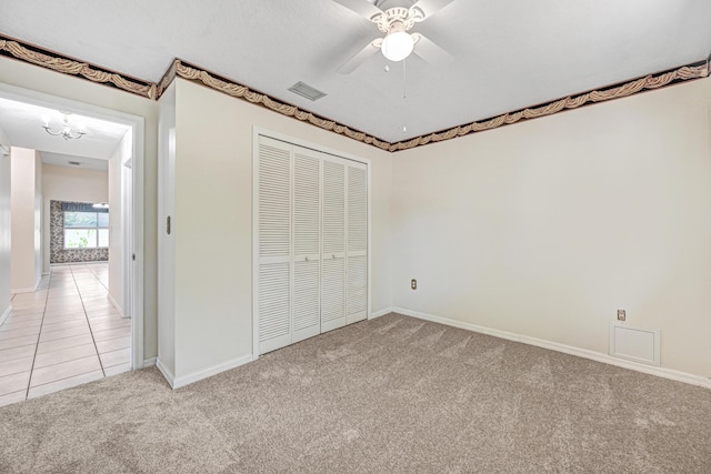 unfurnished bedroom featuring a closet, light colored carpet, and ceiling fan