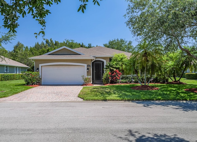 single story home featuring a garage and a front yard