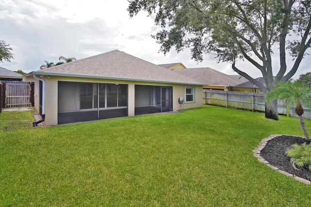 back of house featuring a yard and a sunroom