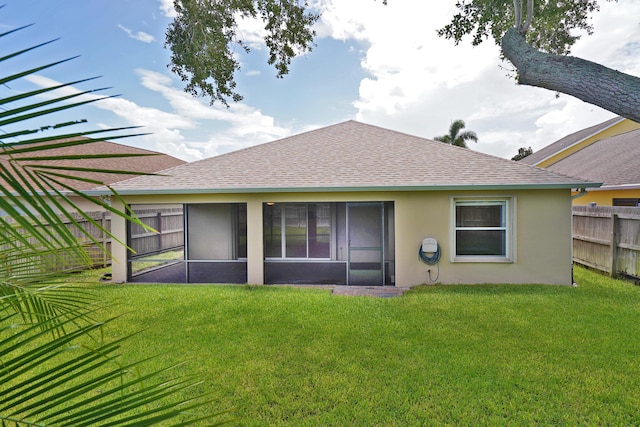 back of property with a yard and a sunroom