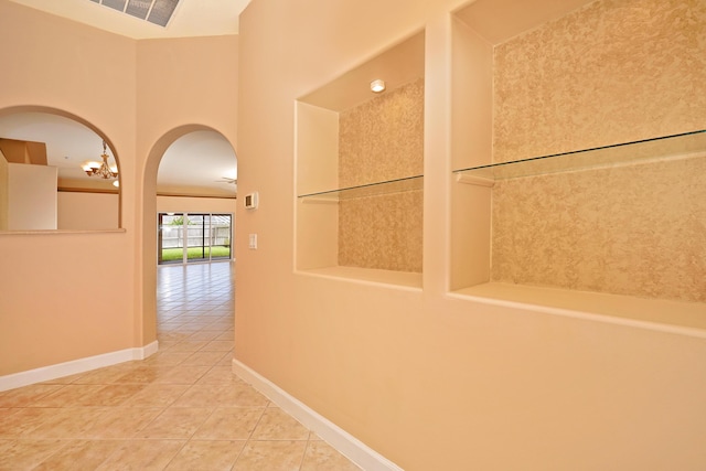 corridor with built in shelves and tile patterned floors