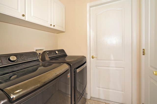 washroom with cabinets and washing machine and clothes dryer