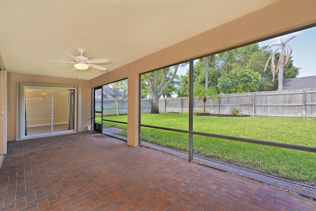 unfurnished sunroom featuring ceiling fan