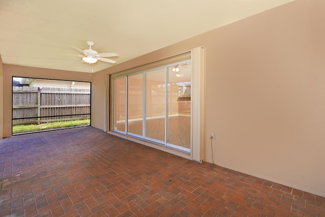 unfurnished sunroom featuring ceiling fan