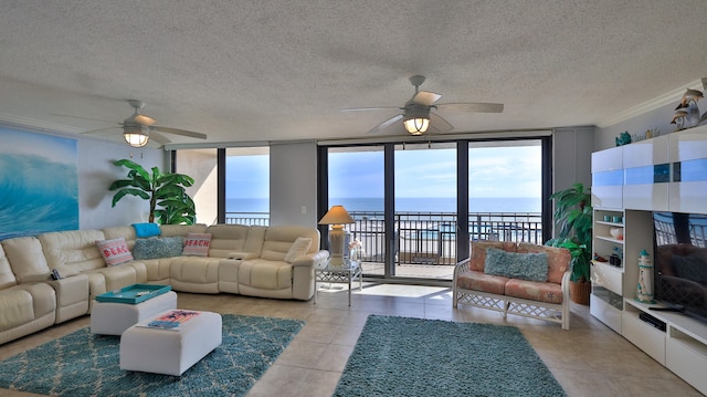 living room with ceiling fan, a textured ceiling, light tile flooring, and a water view