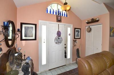 tiled foyer entrance featuring lofted ceiling