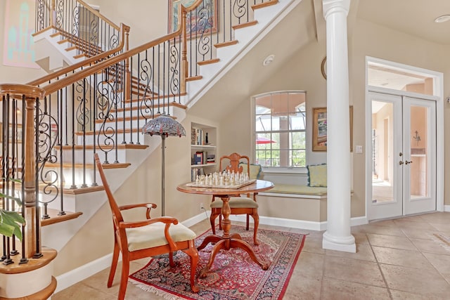 stairway featuring ornate columns and french doors