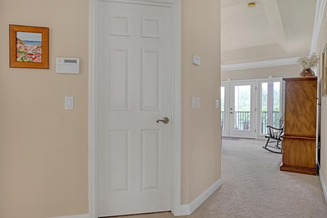 hallway featuring light carpet and a tray ceiling