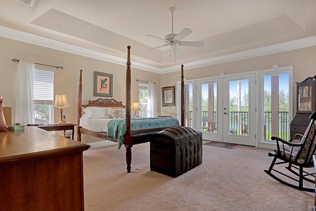 bedroom with a raised ceiling, light carpet, access to outside, and french doors