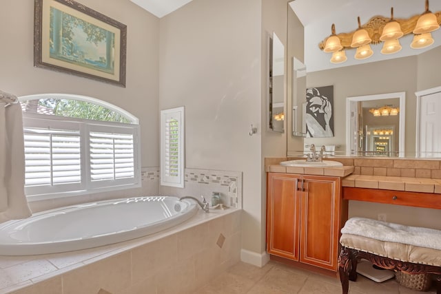 bathroom featuring tiled tub, tile patterned flooring, and vanity