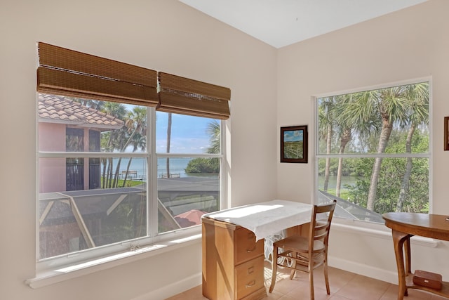 tiled dining space with plenty of natural light and a water view