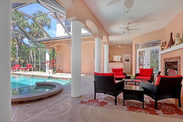 view of patio with ceiling fan, a swimming pool with hot tub, an outdoor living space, and glass enclosure