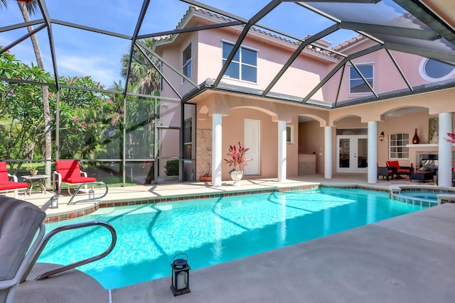 view of pool with a lanai, an in ground hot tub, french doors, and a patio