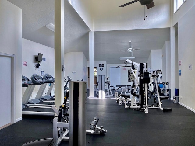 exercise room with ceiling fan, high vaulted ceiling, and a textured ceiling